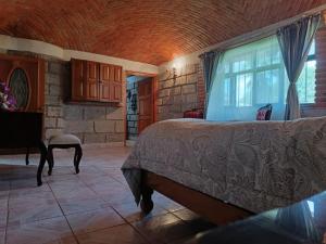a bedroom with a large bed and a window at Villa Colibri in Tequisquiapan