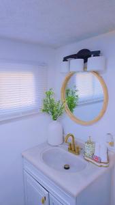 Un baño con un lavabo y un espejo en la pared. en the paradise house 10 minutes from the beach, en North Rose