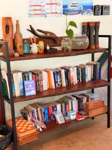 un estante lleno de libros en una habitación en Eve house koh kood, en Ko Kood