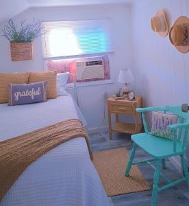 Un dormitorio con una cama, una silla y un escritorio. en the paradise house 10 minutes from the beach, en North Rose