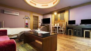 a hotel room with a bed and a desk in a room at 프롬에이치 아모레미오 더클래식 수원역 in Suwon +31 photos