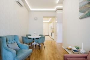 uma sala de estar com um sofá azul e uma mesa em Synagogue Skyline View Walk to Deák & Fashion St em Budapeste