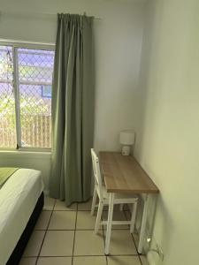 a bedroom with a table and a bed and a window at Double room with shared bathoom in Auburn