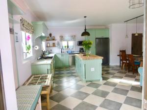 a kitchen with green cabinets and a checkered floor at Whistlewood Guesthouse Walmer, Port Eizabeth in Port Elizabeth