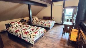 a bedroom with two beds and a table and a window at 天空のお宿 雅館 in Ichinoseki