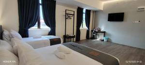 a hotel room with two beds and a flat screen tv at The Great Hotel Sri Iskandar in Seri Iskandar