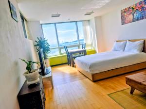 a bedroom with a bed and a table and a window at Cozy - Experience Home like Comfort Studio in Incheon
