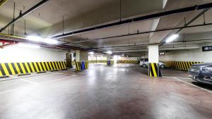an empty parking garage with cars parked in it at 프롬에이치 아모레미오 더클래식 수원역 in Suwon