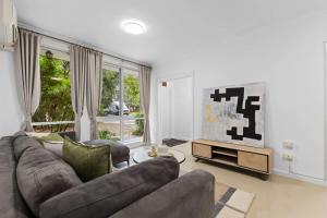 a living room with a couch and a television at Prime location 3-bedder just moments from Central Park in Glen Iris
