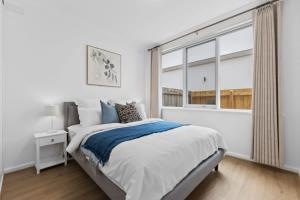 a bedroom with a bed and a large window at Prime location 3-bedder just moments from Central Park in Glen Iris +6 photos