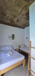a bedroom with two beds and a wooden ceiling at Camotes Hostel Resort in Camotes Islands