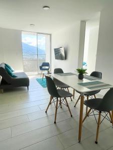 a living room with a table and chairs and a couch at Hermoso Apartamento Nuevo con Excelente Vista in Ibagué
