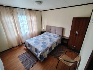 Un dormitorio con una cama y una cómoda y una ventana. en Subantartica Hostel House, en El Cerrillo