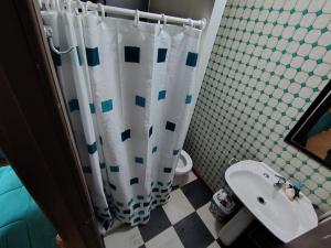 Un baño con cortina de ducha y lavabo. en Subantartica Hostel House, en El Cerrillo 2 fotos más
