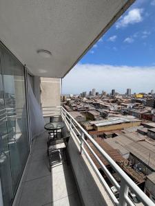 a balcony with two chairs and a view of a city at Espectacular Depto en Cavancha in Iquique