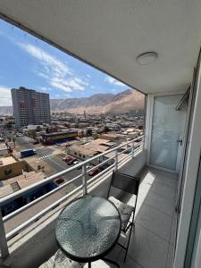 a balcony with a table and chairs and a view of a city at Espectacular Depto en Cavancha in Iquique
