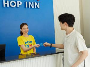 ローイエットにあるHOP INN Roi Etの看板前に立つ男女