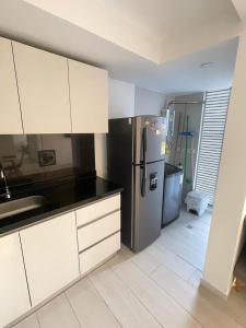a kitchen with a stainless steel refrigerator and white cabinets at Hermoso Apartamento Nuevo con Excelente Vista in Ibagué +1 photo