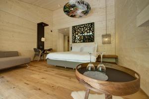 a bedroom with a bed and a tub in it at Hotel Rovanada Wellness & BergNatur in Vals