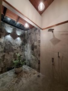 a bathroom with a shower and a potted plant at River Shades Hotel in Hikkaduwa
