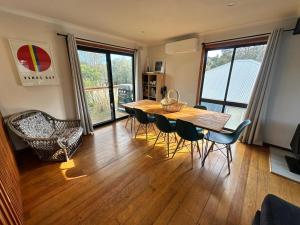 a dining room with a wooden table and chairs at Saturn Sands - 30 Saturn Parade in Venus Bay