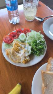 a plate of food with tomatoes and vegetables on a table at ZOZO Sapa Homestay & Trekking in Sa Pa