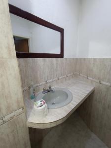 a bathroom with a sink with a mirror and a towel at Mini apartamento 2 habitaciones in Ciudad Guayana