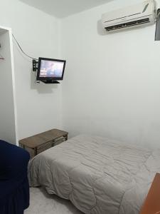a bedroom with a bed and a tv on the wall at Mini apartamento 2 habitaciones in Ciudad Guayana