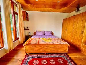 um quarto com uma cama com almofadas roxas em Sharika Homes em Katrain