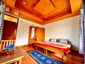 um quarto com uma cama e um teto de madeira em Sharika Homes em Katrain mais 1 fotografia