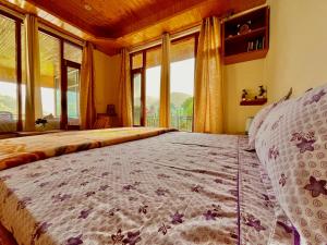 um quarto com uma cama grande e uma janela grande em Sharika Homes em Katrain