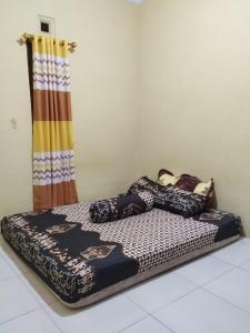 a bed sitting on top of a floor in a room at 563 Homestay Jogja in Ngabean