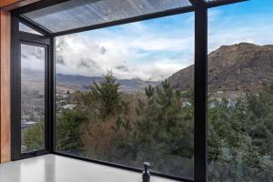 a large window with a view of the mountains at Family-Friendly Chalet Mountain Views in Frankton Wharf