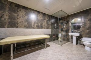 a bathroom with a bench and a toilet and a sink at 프롬에이치 아모레미오 더클래식 수원역 in Suwon