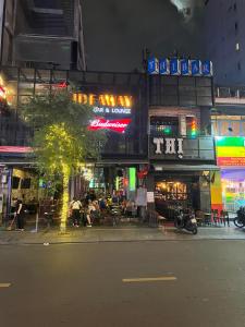 a city street at night with a building with neon signs at Homestay Ms. Hoa in Ho Chi Minh City