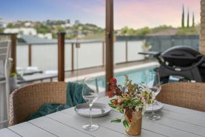 a table with two wine glasses and a vase of flowers at Burleigh Heads Family Getaway in Gold Coast