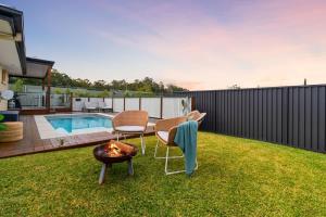 a backyard with two chairs and a fire pit at Burleigh Heads Family Getaway in Gold Coast