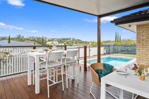a patio with a table and chairs and a pool at Burleigh Heads Family Getaway in Gold Coast