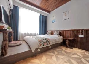 a bedroom with a bed and a large window at Xiaobeilou Inn Zhangjiajie Railway Station Tianmen Mountain Cableway Branch in Zhangjiajie +26 photos