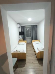 a room with two beds and a window at Qorjyn Hotel in Shymkent
