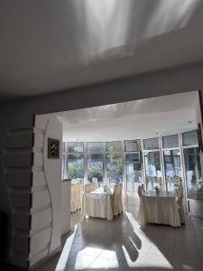a dining room with tables and chairs and windows at Qorjyn Hotel in Shymkent