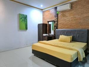 a bedroom with a bed and a brick wall at Wanajaya Homestay 