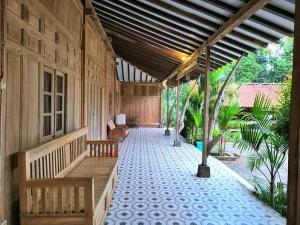 a porch of a house with two wooden benches at Wanajaya Homestay 