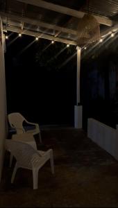 a dark room with two chairs and a pendant light at El Cortijo  +14 photos
