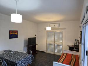 a room with a bed and a table and a window at Aguaribay 1 in Chilecito