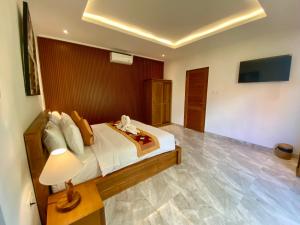 Un dormitorio con una cama y una lámpara sobre una mesa. en The L'bok Guesthouse Ubud, en Ubud