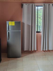 a refrigerator in a room with a window at Cheni's in Quesada