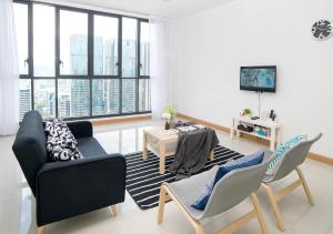 a living room with two chairs and a table at Karaoke Party Penthouse at KL Gateway by Cobnb in Kuala Lumpur
