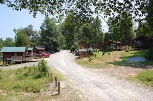 a dirt road next to a village with houses at Forest Lake Camping Resort Cabin 18 in Freewood Acres