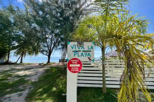 a sign on the beach next to a fence at Fare Tokatea - Charming Studio w Excl Beach Access in Iumaru